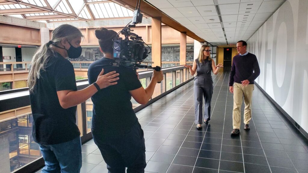 BTS_Novata_WEB-004 Hallway scene with camera operator walking backwards at Ford Foundation
