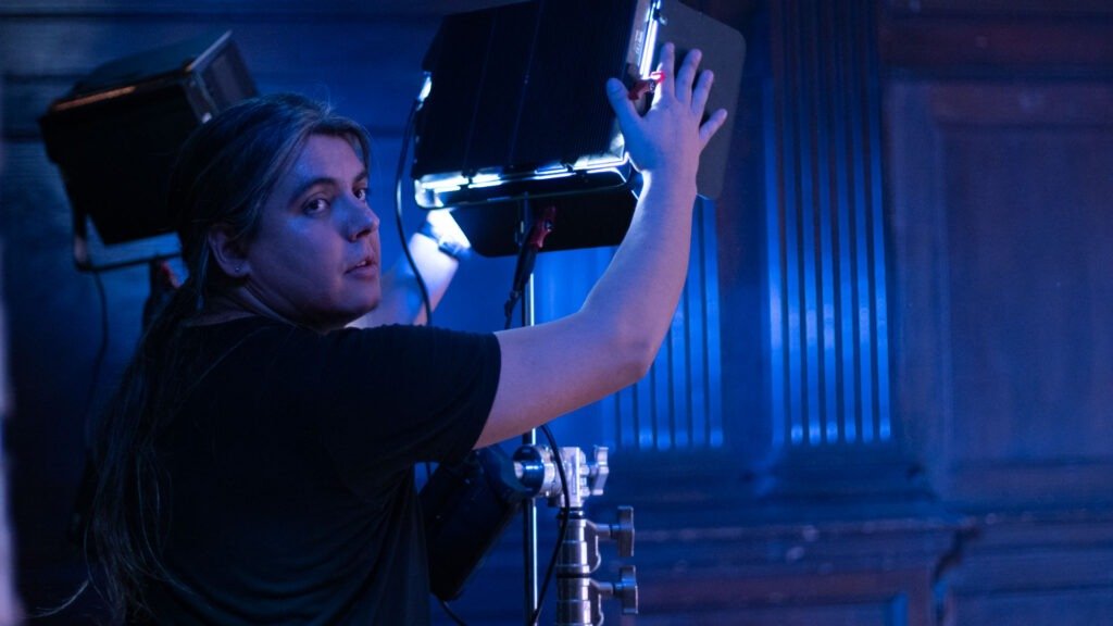 DreamPlay_BTS_Tap-with-Me_003_WEB Gaffer setting up lights and looking at director.