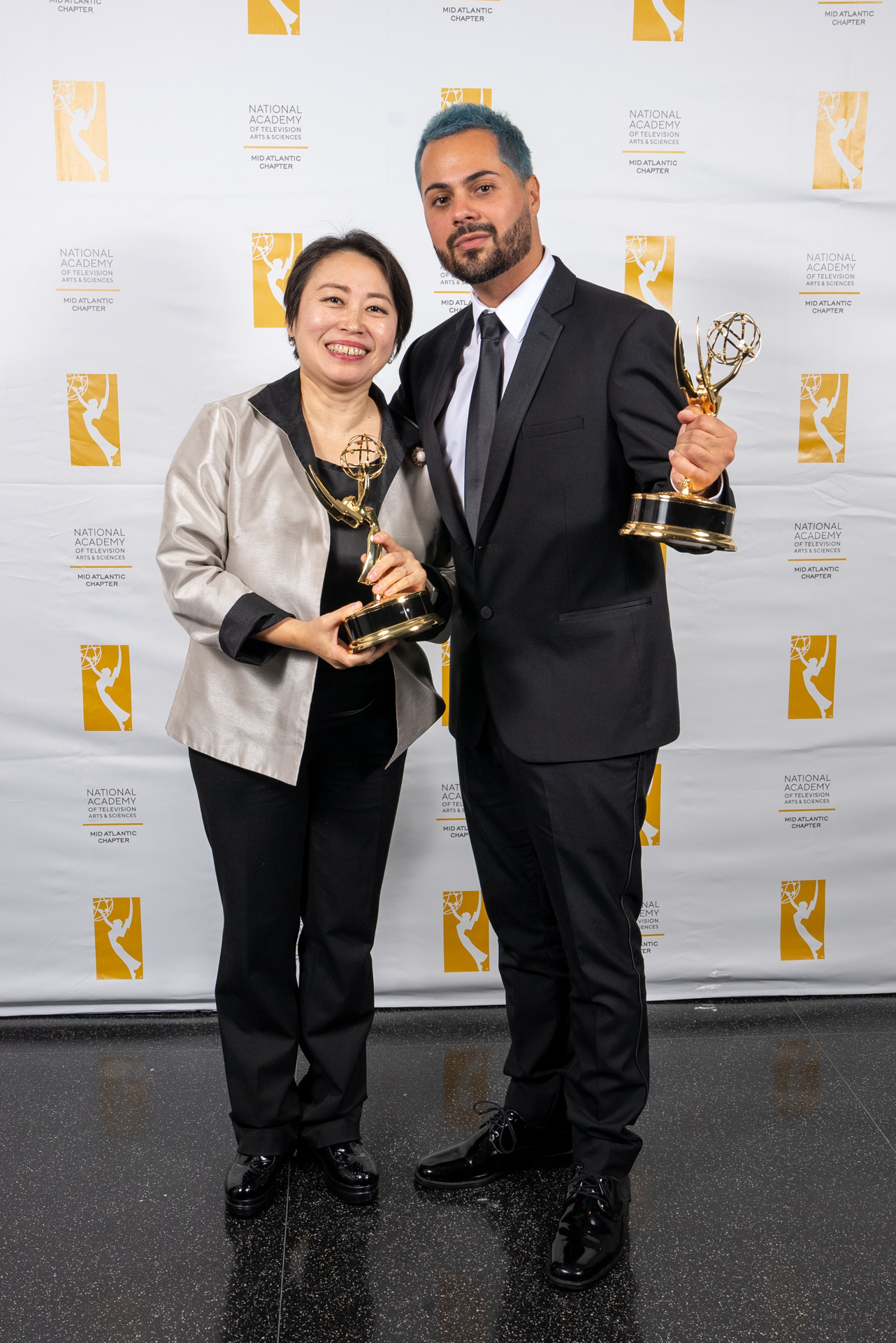 Director Yuri Alves and conductor Xian Zhang holding Emmy statuettes