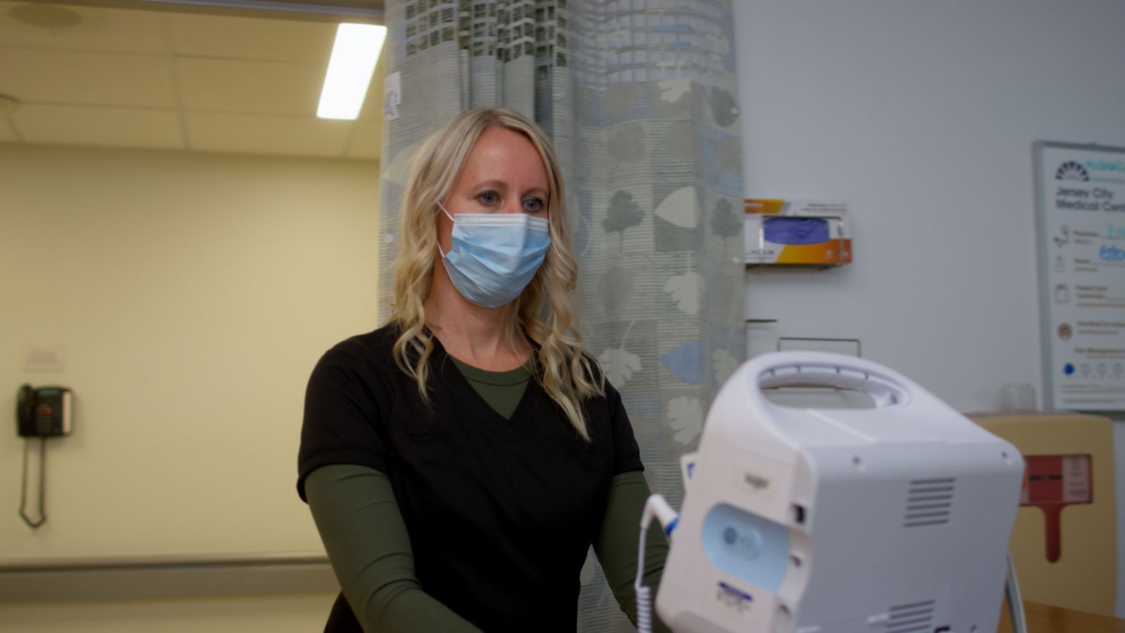 Nurse moving hospital equipment on cart